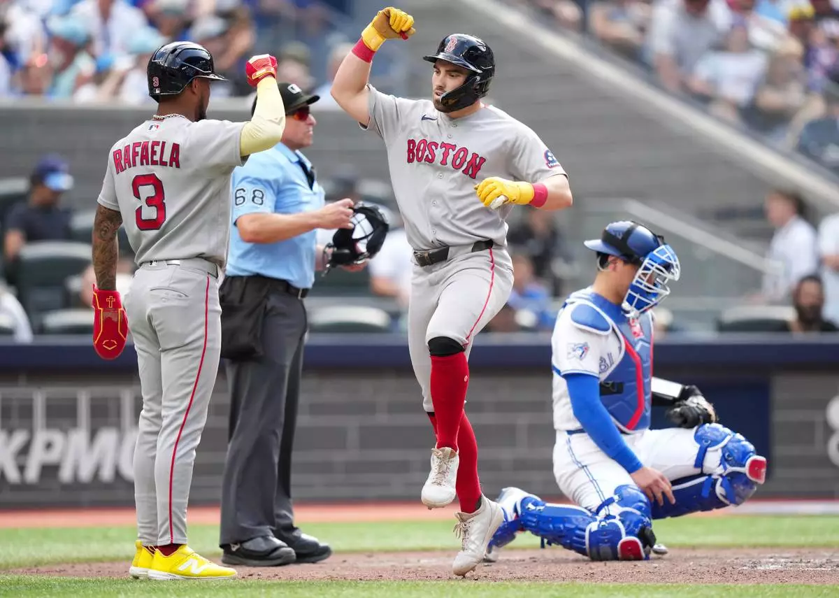 Boston Red Sox third baseman Caleb Durbin (5) celebrates his grand slam with teammate Ceddanne Rafaela (3) as Toronto Blue Jays catcher Brandon Valenzuela (59) looks on during the eighth inning of a baseball game in Toronto, Thursday, Aug. 13, 2026. (Nathan Denette/The Canadian Press via AP)
