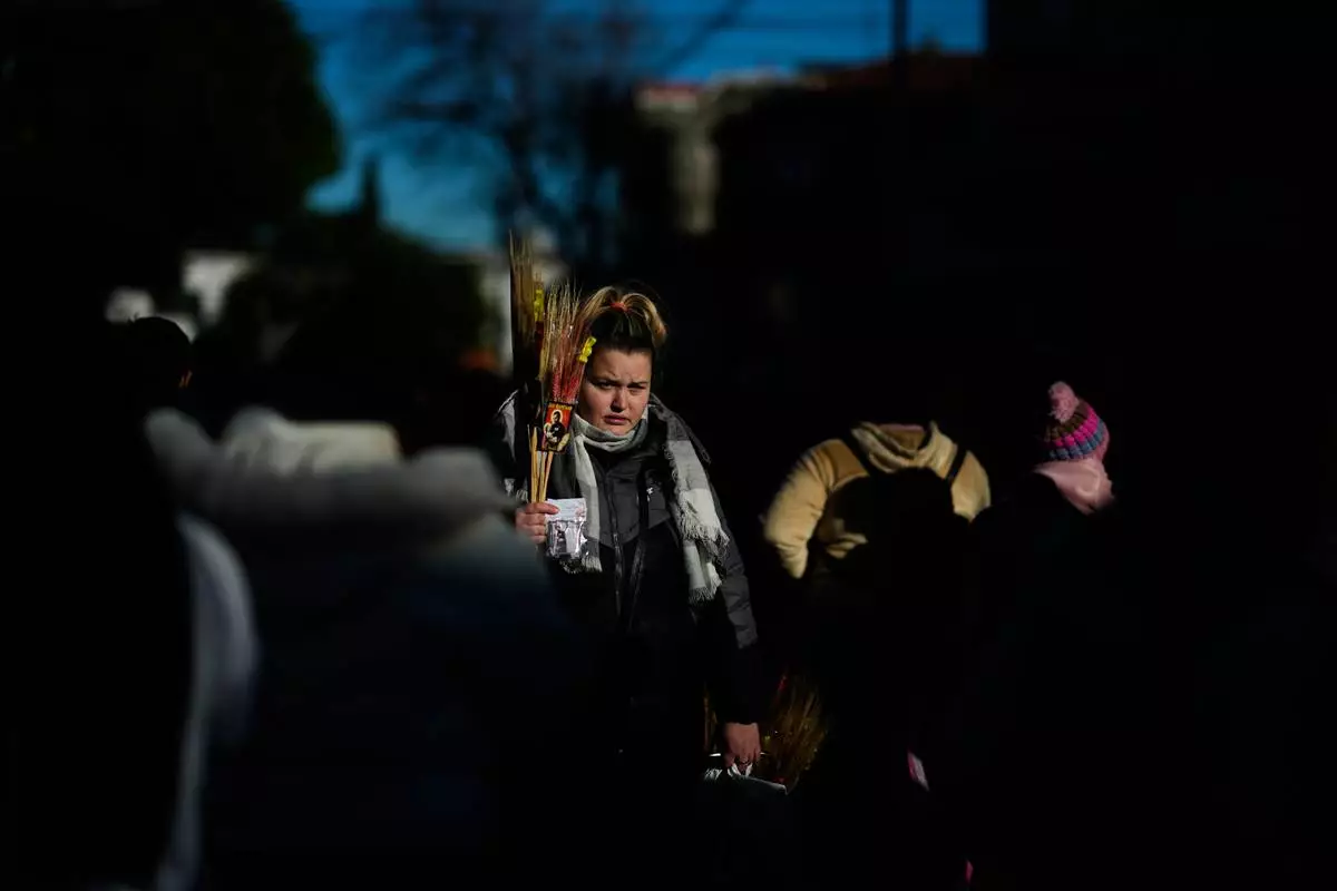 A religious souvenir vendor stands amid pilgrims waiting to enter the Church of San Cayetano during the annual pilgrimage honoring Saint Cajetan, the patron saint of work, in Buenos Aires, Argentina, Friday, Aug. 7, 2026. (AP Photo/Natacha Pisarenko)