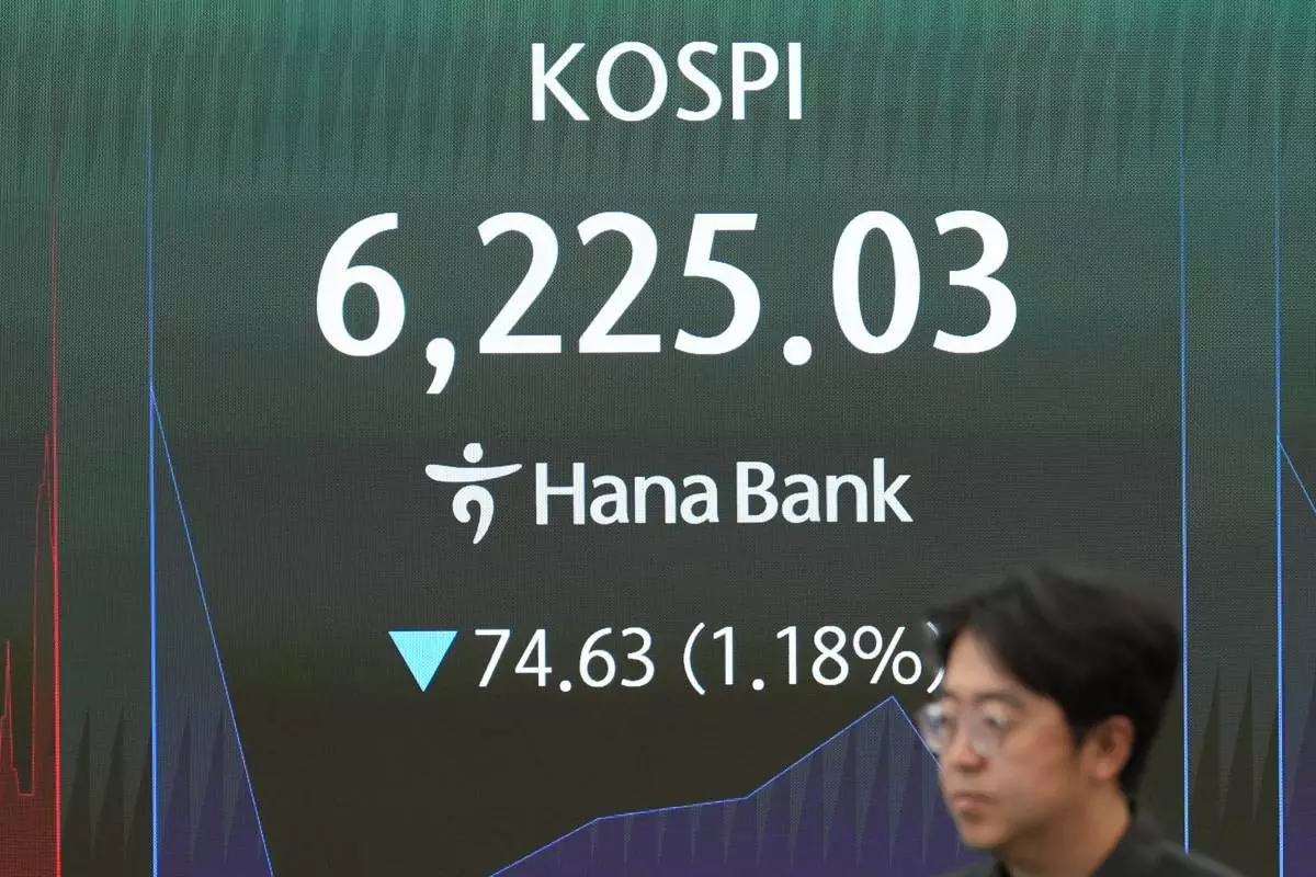 An employee walks past near the screen showing the Korea Composite Stock Price Index (KOSPI) at a dealing room of Hana Bank in Seoul, South Korea, Tuesday, Aug. 11, 2026. (AP Photo/Lee Jin-man)