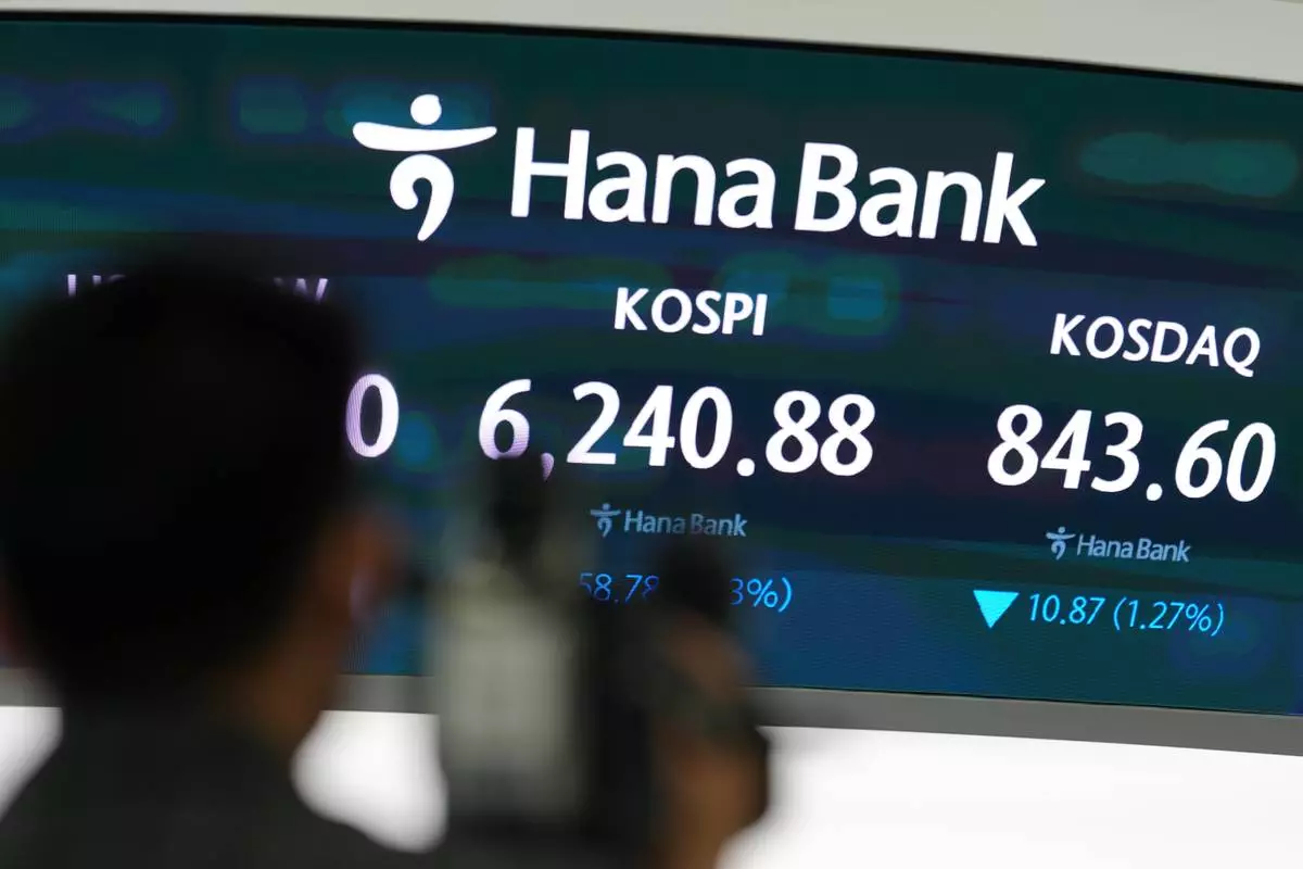 A TV cameraman prepares to film near the screens showing the Korea Composite Stock Price Index (KOSPI) and the Korean Securities Dealers Automated Quotations (KOSDAQ) at a dealing room of Hana Bank in Seoul, South Korea, Tuesday, Aug. 11, 2026. (AP Photo/Lee Jin-man)