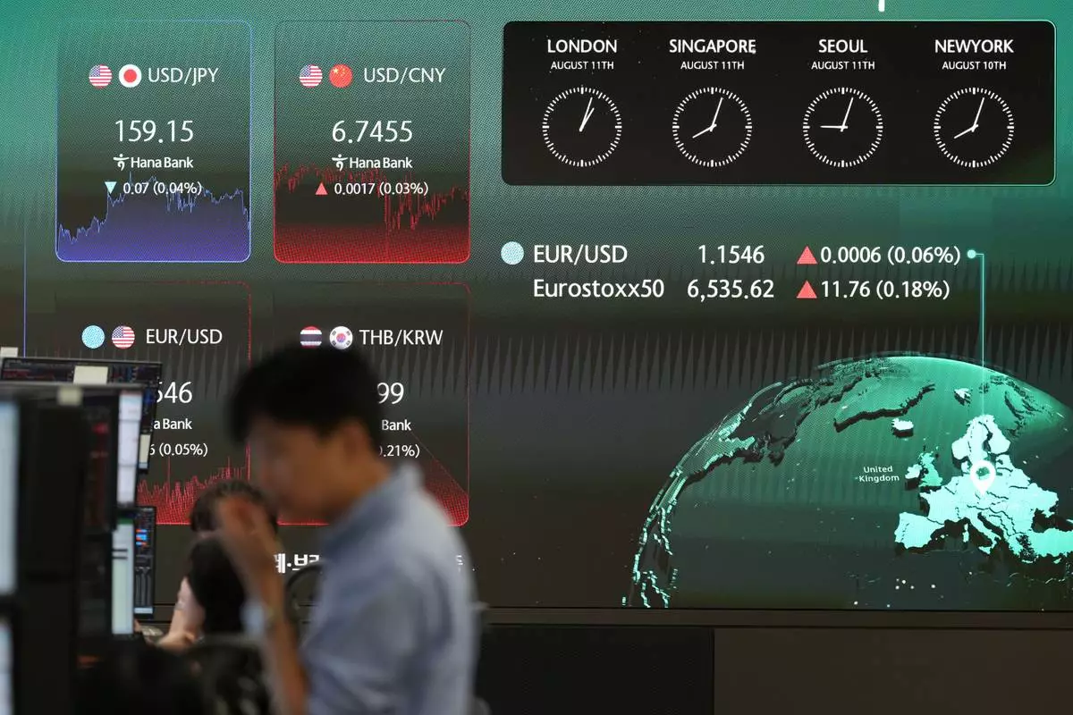 A dealer stands near the screens showing the foreign exchange rates at a dealing room of Hana Bank in Seoul, South Korea, Tuesday, Aug. 11, 2026. (AP Photo/Lee Jin-man)