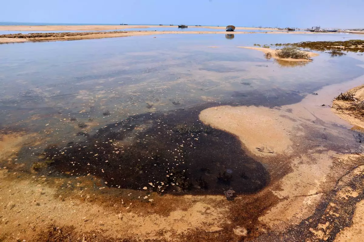 Dark oil residue collects in shallow coastal waters on Qeshm Island, Iran, Thursday, Aug. 13, 2026, amid ongoing wartime attacks on vessels and infrastructure in and around the Strait of Hormuz, though the spill's source has not been independently determined.(Amirhosein Khorgooi/ISNA via AP)