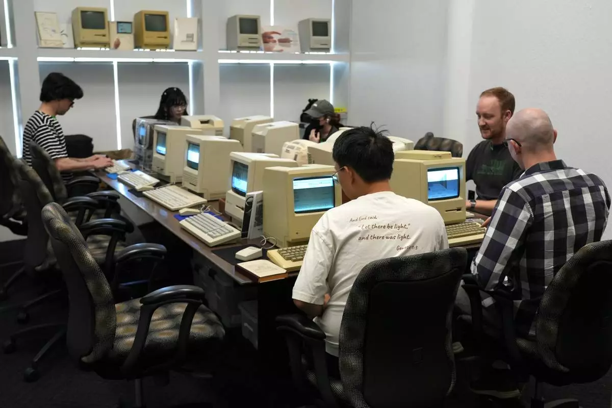 Attendees play on Apple Macintosh computers from the 1980s at the Vintage Computer Festival in Mountain View, Calif., Sunday, Aug. 2, 2026. (AP Photo/Terry Chea)