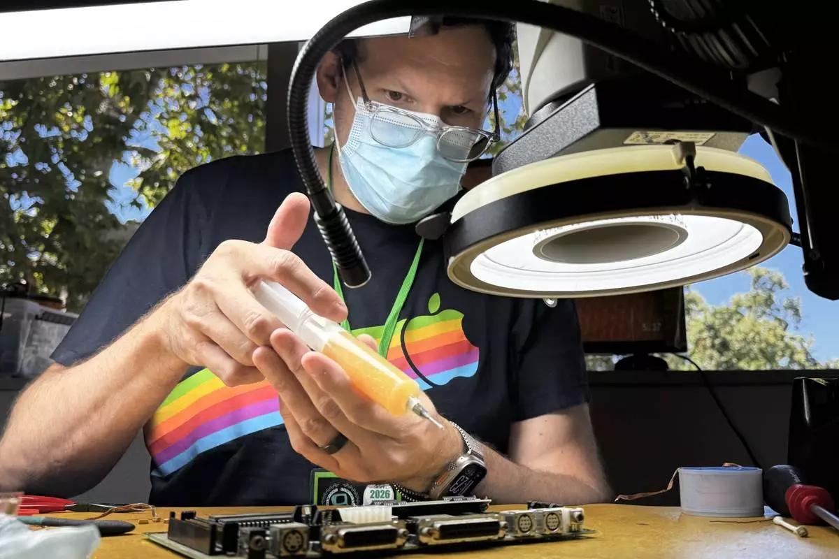 Arion Paylo repairs a circuit board at the Vintage Computer Festival in Mountain View, Calif., Sunday, Aug. 2, 2026. (AP Photo/Terry Chea)
