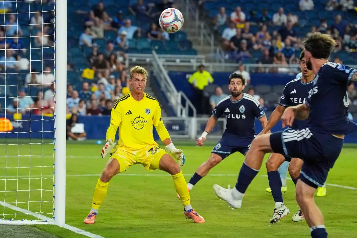 Sporting Kansas City goalkeeper Stefan Cleveland (30) watches a shot by Vancouver Whitecaps' Tristan Blackmon, right, go over the goal during the second half of an MLS soccer match against Sporting Kansas City Saturday, Aug. 29, 2026, in Kansas City, Kan. (AP Photo/Charlie Riedel)