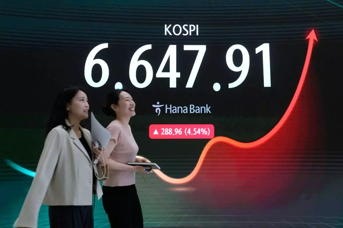 Currency traders pass by a screen showing the Korea Composite Stock Price Index (KOSPI) at the foreign exchange dealing room of the Hana Bank headquarters in Seoul, South Korea, Wednesday, Aug. 5, 2026. (AP Photo/Ahn Young-joon)