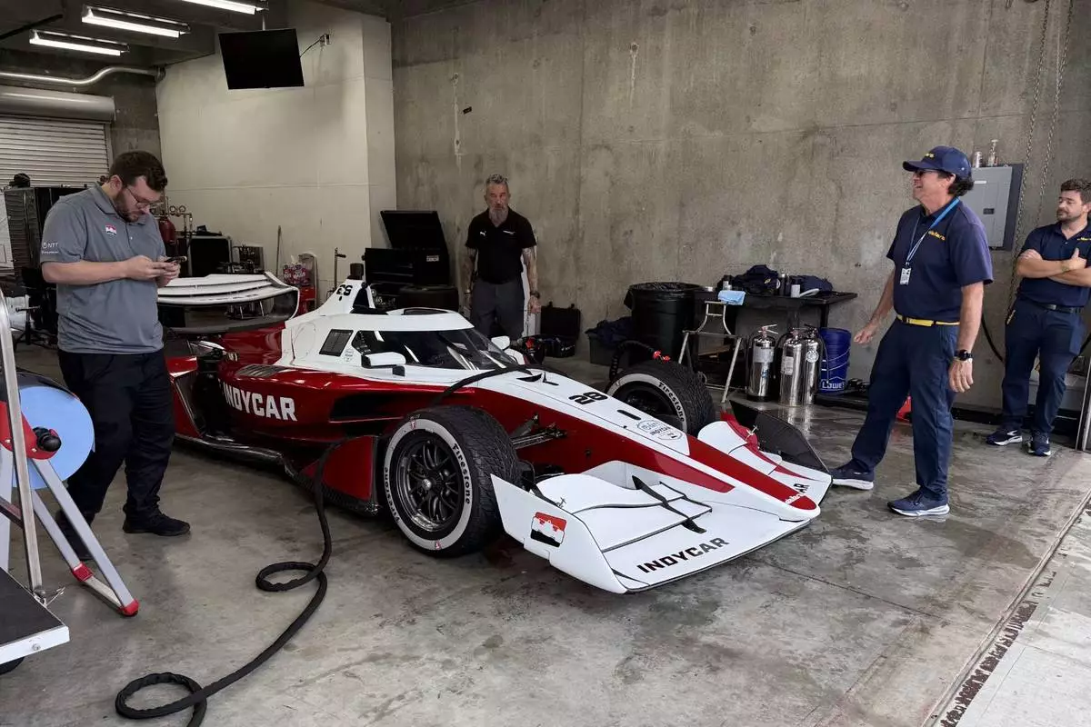 Officials from chassis manufacturer Dallara work on the new IndyCar model, Sunday, Aug. 2, 2026, at Indianapolis Motor Speedway in Indianapolis. (AP Photo/Mike Marot)