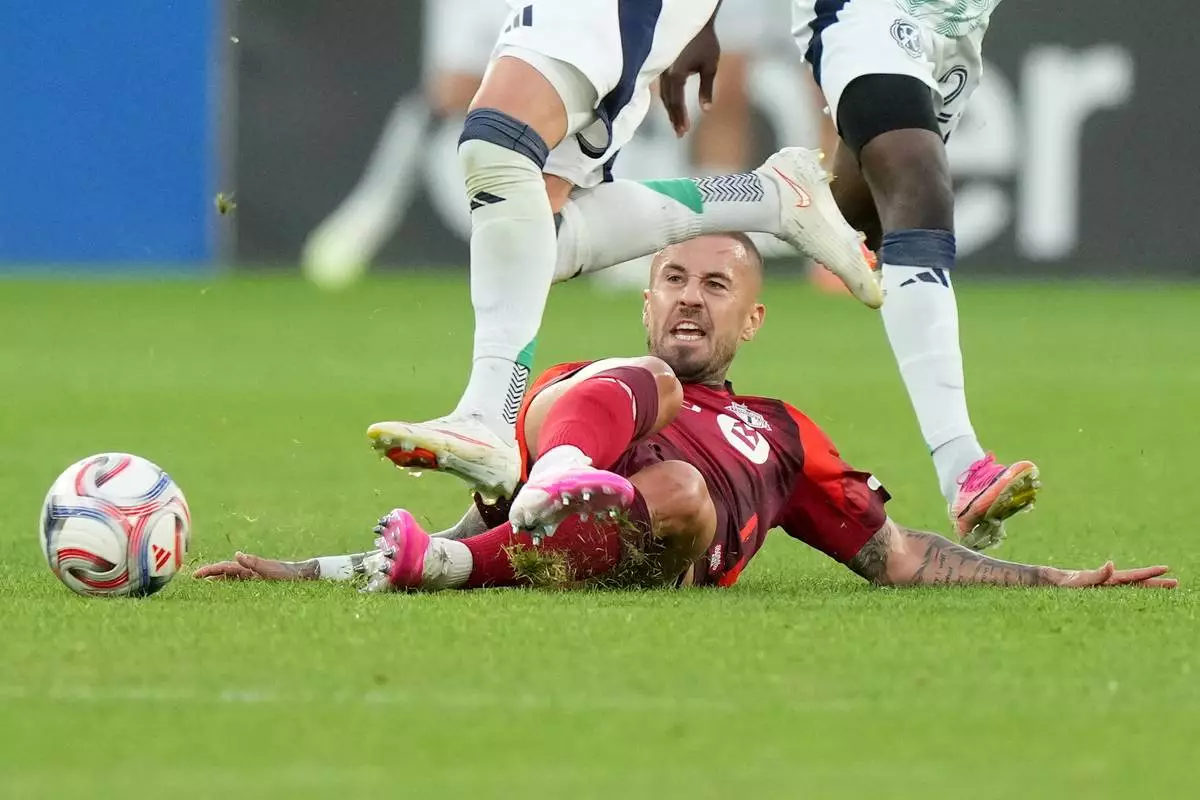 Toronto FC midfield Niklas Dorsch (6) gets tripped up by New England Revolution midfield Brooklyn Raines during the first half of a MLS soccer game in Toronto, Saturday, Aug. 15, 2026. (Nathan Denette/The Canadian Press via AP)
