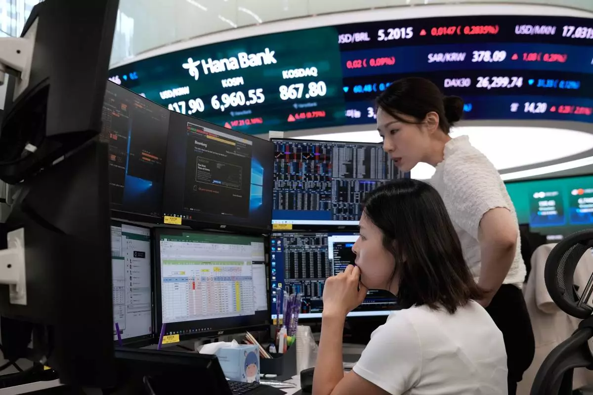 Currency traders work at the foreign exchange dealing room of the Hana Bank headquarters in Seoul, South Korea, Friday, Aug. 14, 2026. (AP Photo/Ahn Young-joon)