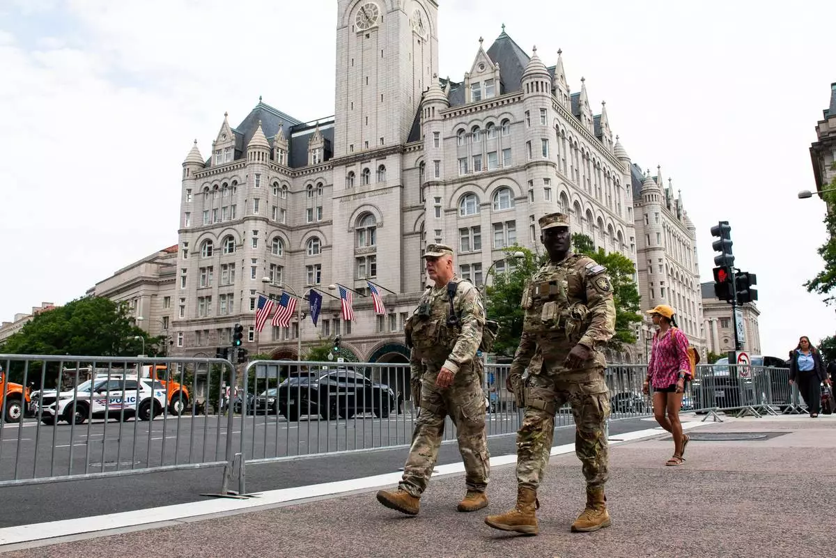 National Guard troops walk across the street from the Waldorf Astoria hotel where President Donald Trump will attend the White House Correspondents' Association Dinner, in Washington, Friday, July 24, 2026. (AP Photo/Cliff Owen)