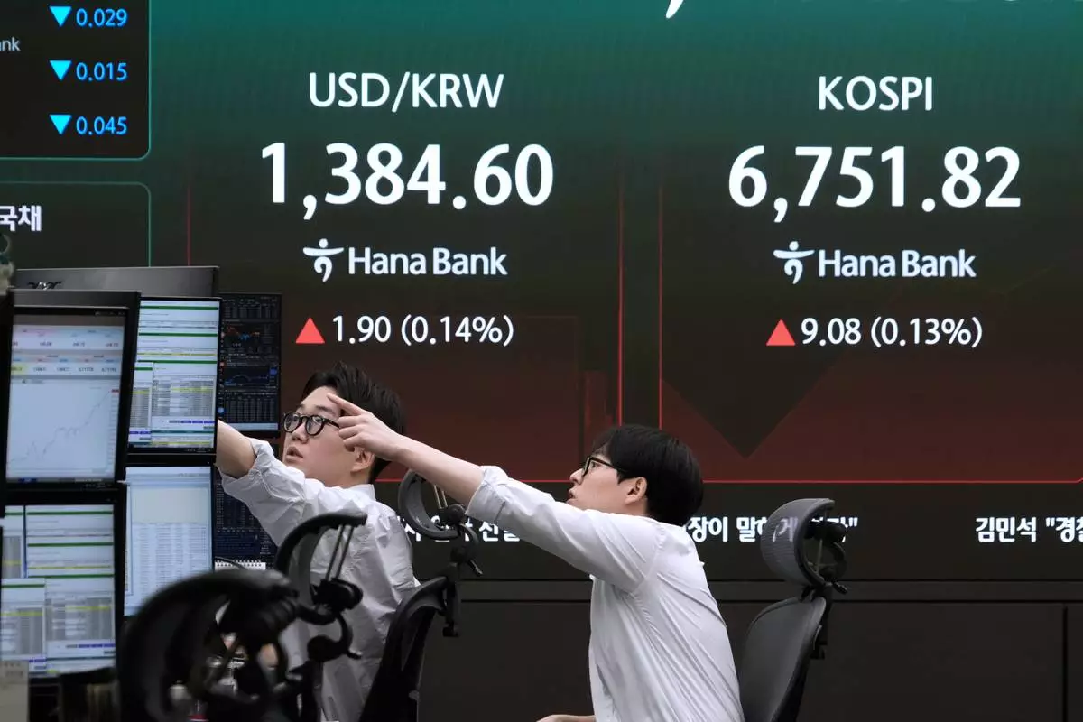 Currency traders watch monitors near a screen showing the Korea Composite Stock Price Index (KOSPI) and the foreign exchange rate between U.S. dollar and South Korean won at the foreign exchange dealing room of the Hana Bank headquarters in Seoul, South Korea, Wednesday, Aug. 26, 2026. (AP Photo/Ahn Young-joon)
