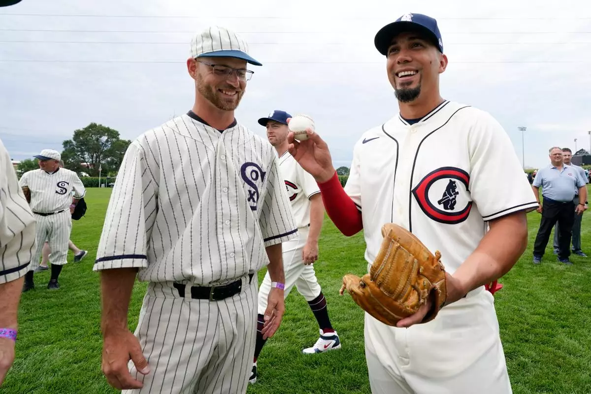 FILE - Field of Dreams "ghost" player Russ Bolibaugh, left, of Dyersville, Iowa, talks with Chicago Cubs center fielder Rafael Ortega, right, before a baseball game against the Cincinnati Reds at the Field of Dreams movie site, Aug. 11, 2022, in Dyersville, Iowa. (AP Photo/Charlie Neibergall, File)