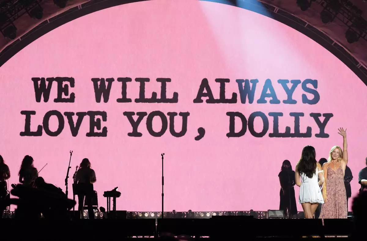 Special guest Sarah McLachlan, right, waves to the audience after she and Olivia Rodrigo dedicated a song to the late Dolly Parton during Rodrigo's set at the Daisy Chain Fields Music Festival on Saturday, Aug. 29, 2026, at Great Park in Irvine, Calif. (AP Photo/Chris Pizzello)
