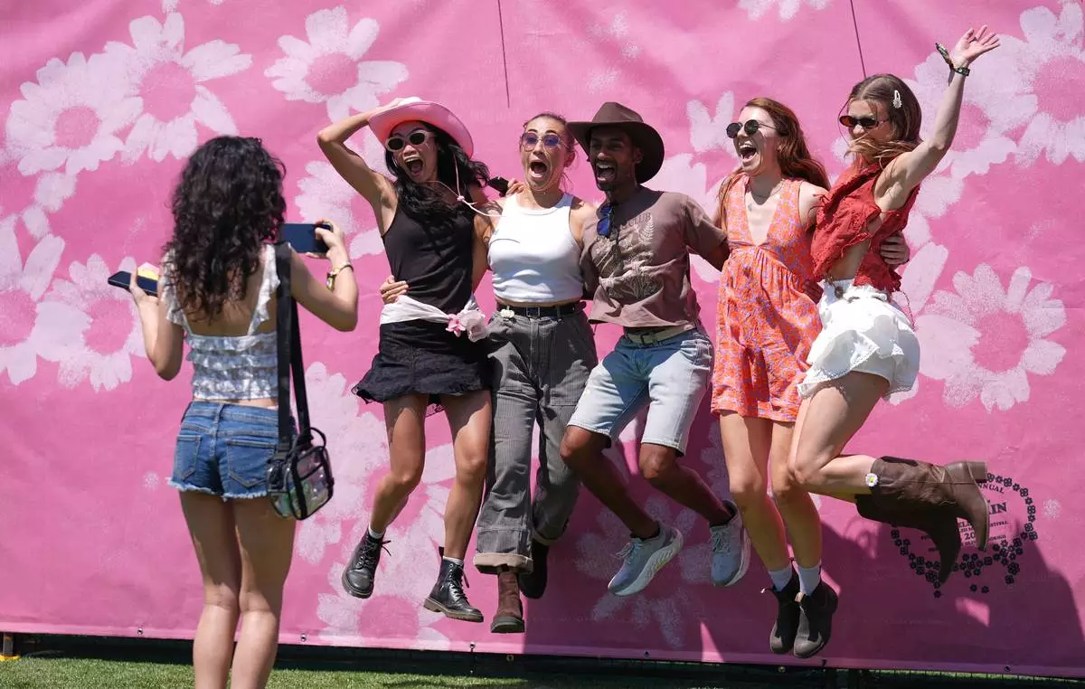 Festivalgoers leap in the air together for a group photo at the Daisy Chain Fields Music Festival at Great Park in Irvine, Calif., Saturday, Aug. 29, 2026. (AP Photo/Chris Pizzello)