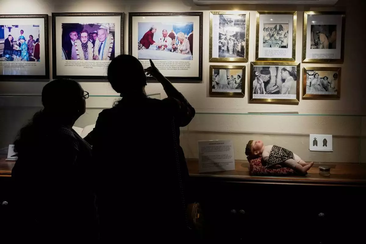 Visitors view photos displayed inside a museum showcasing Cochin's Jewish history next to the 458-year-old Paradesi Synagogue in the historic Jew Town neighborhood of Kochi, India, Wednesday, May 20, 2026. (AP Photo/Aijaz Rahi)