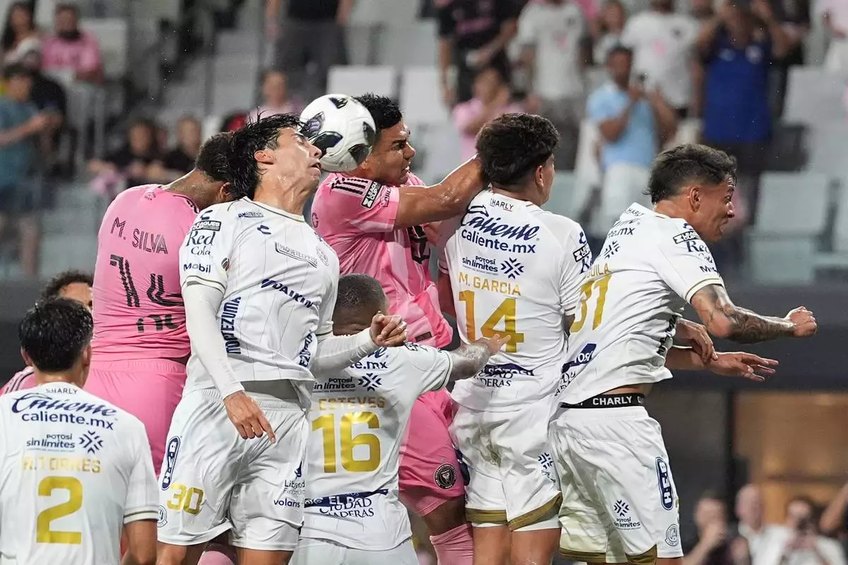 Inter Miami defender Micael (14) heads the ball past Atletico de San Luis defender Benjamin Galindo (30) and Inter Miami midfielder Casemiro (5) to score the team's fourth goal during the first half of a Leagues Cup soccer match, Wednesday, Aug. 5, 2026, in Miami. (AP Photo/Rebecca Blackwell)