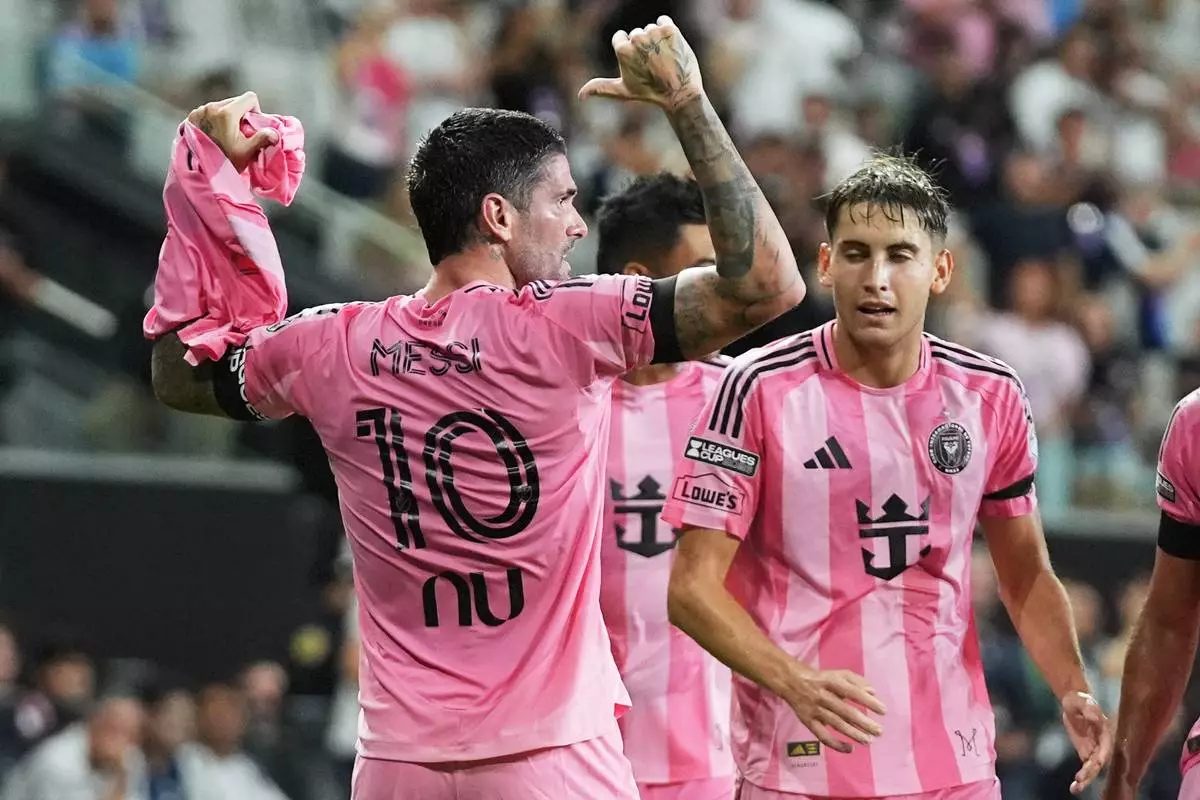 Inter Miami midfielder Rodrigo de Paul, left, celebrates after scoring a goal, wearing the shirt of teammate Lionel Messi (10) who did not play due to death of his father, during the first half of a Leagues Cup soccer match against Monterrey, Saturday, Aug. 8, 2026, in Miami. (AP Photo/Lynne Sladky)