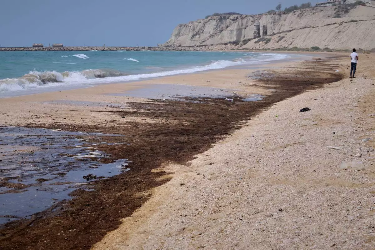 Dark oil residue covers parts of the shoreline at Shib Deraz Beach on Qeshm Island, Iran, Thursday, Aug. 13, 2026, amid ongoing wartime attacks on vessels and infrastructure in and around the Strait of Hormuz, though the spill’s source has not been independently determined. (Amirhosein Khorgooei/ISNA)