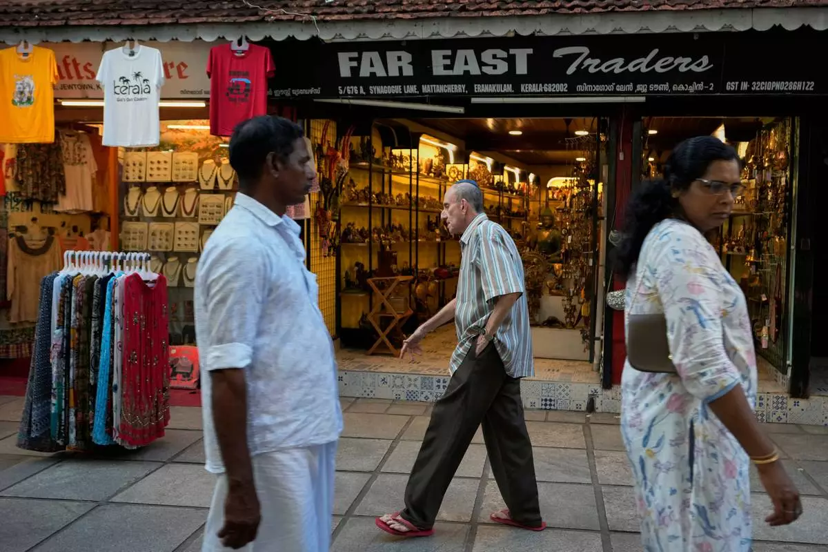 Keith Hallegua, center, walks past a handicrafts store toward the 458-year-old Paradesi Synagogue in the historic Jew Town neighborhood of Kochi, India, Thursday, May 21, 2026. (AP Photo/Aijaz Rahi)