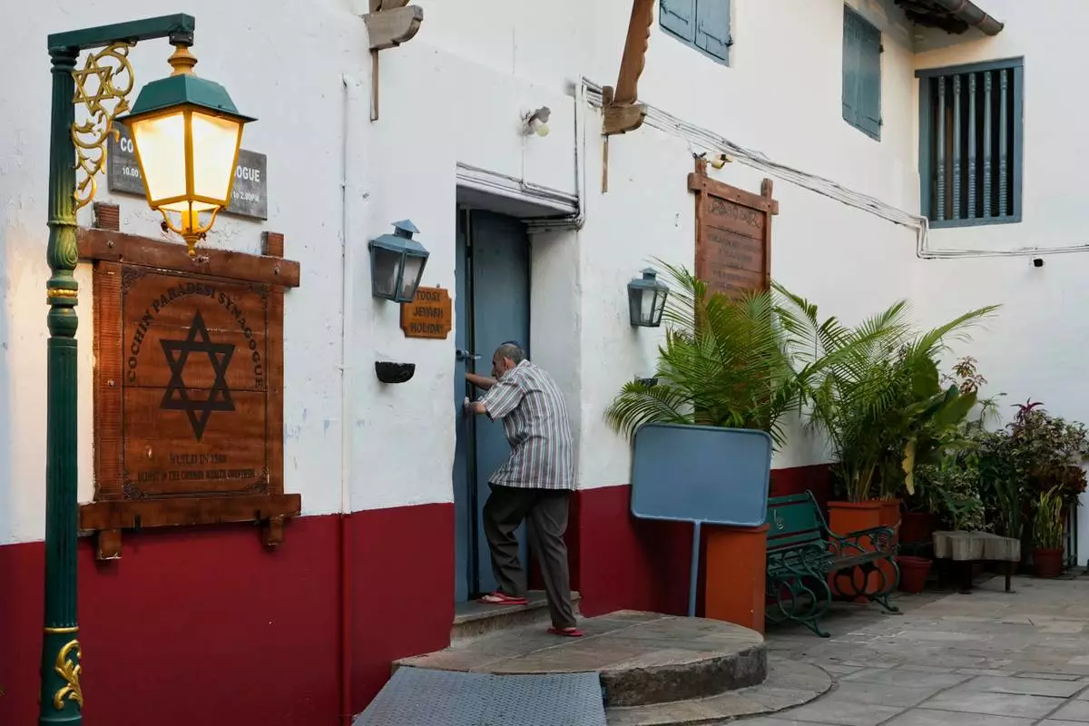 Keith Hallegua, a Paradesi Jew, opens the door to enter the 458-year-old Paradesi Synagogue in the historic Jew Town neighborhood of Kochi, India, Thursday, May 21, 2026. (AP Photo/Aijaz Rahi)