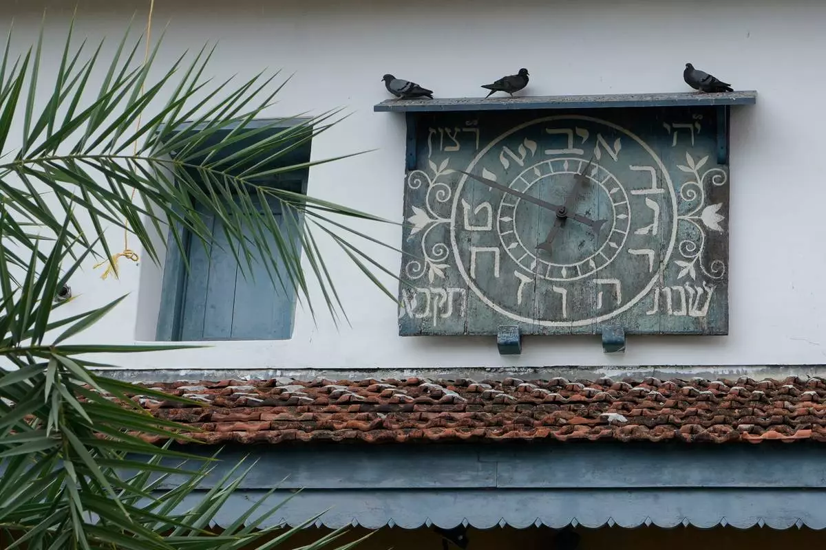 Birds sit on the wooden ledge above an ornate Hebrew clock on the 458-year-old Paradesi Synagogue in the historic Jew Town neighborhood of Kochi, India, Wednesday, May 20, 2026. (AP Photo/Aijaz Rahi)