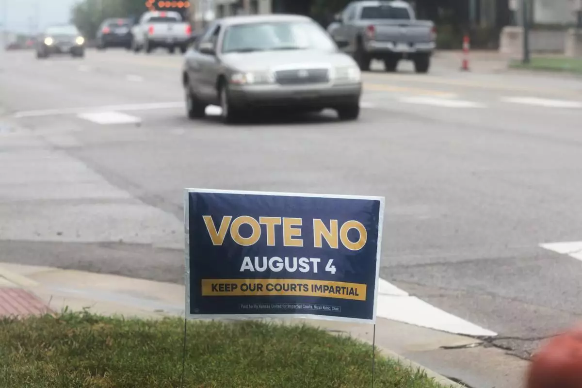 A sign encourages voters to reject a proposal to change how Kanas Supreme Court justices are seated in Topeka, Kan., on Thursday, July 30, 2026. (AP Photo/John Hanna)
