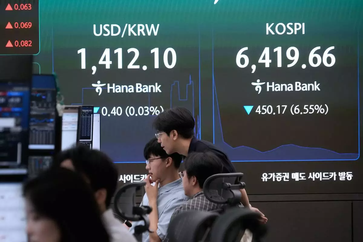Currency traders watch monitors near a screen showing the Korea Composite Stock Price Index (KOSPI) and the foreign exchange rate between U.S. dollar and South Korean won at the foreign exchange dealing room of the Hana Bank headquarters in Seoul, South Korea, Wednesday, Aug. 19, 2026. (AP Photo/Ahn Young-joon)