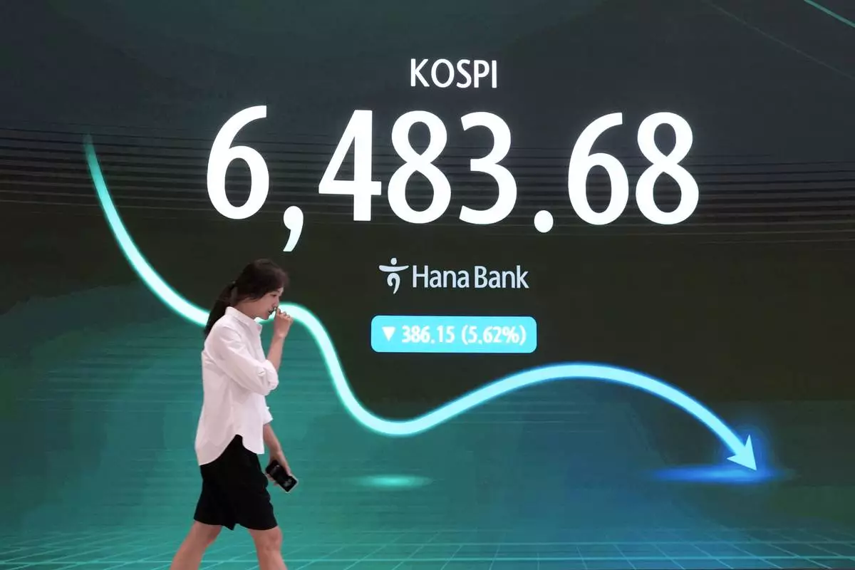 A currency trader passes by a screen showing the Korea Composite Stock Price Index (KOSPI) at the foreign exchange dealing room of the Hana Bank headquarters in Seoul, South Korea, Wednesday, Aug. 19, 2026. (AP Photo/Ahn Young-joon)