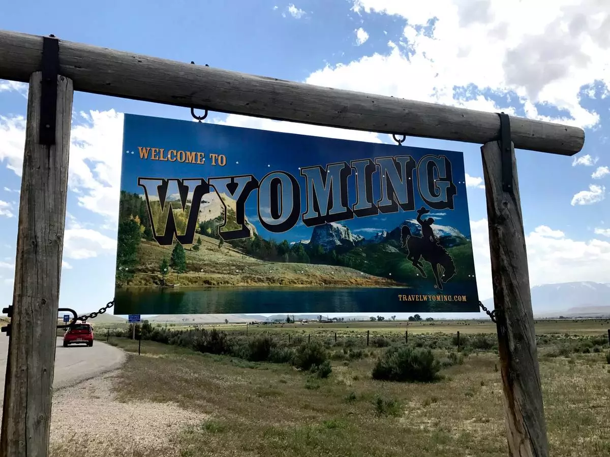 FILE - A sign on the border of Wyoming and Montana appears on the side of Belfry Highway, May 24, 2017, in Powell, Wyoming. (AP Photo/Robert Yoon, File)