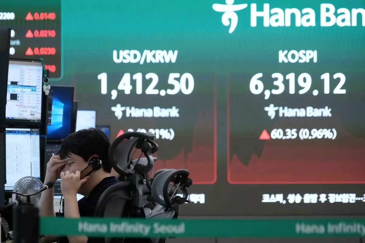 A currency trader talks on the phone near a screen showing the Korea Composite Stock Price Index (KOSPI) and the foreign exchange rate between U.S. dollar and South Korean won at the foreign exchange dealing room of the Hana Bank headquarters in Seoul, South Korea, Monday, Aug. 10, 2026. (AP Photo/Ahn Young-joon)