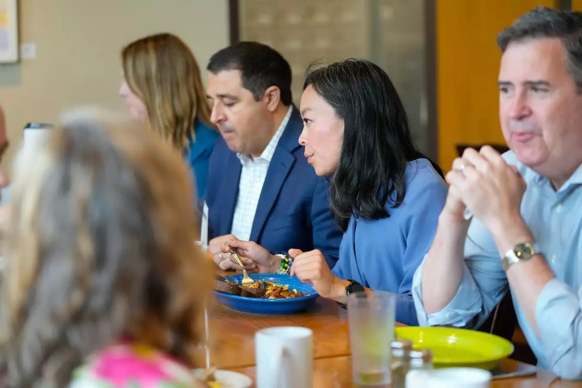 Wisconsin State Rep. Francesca Hong, center, a democratic socialist who was narrowly defeated by David Crowley in the Democratic gubernatorial primary, eats breakfast with Democratic leaders including gubernatorial nominee David Crowley and lieutenant governor nominee Sarah Godlewski at Prairie Cafe and Bakery Wednesday, Aug. 12, 2026, in Middleton, Wis. (AP Photo/Kayla Wolf)