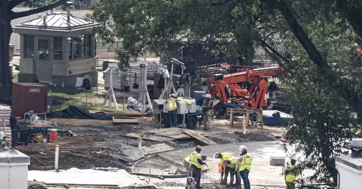 Crews remove the granite seal on the White House helipad, signaling potential project delays
