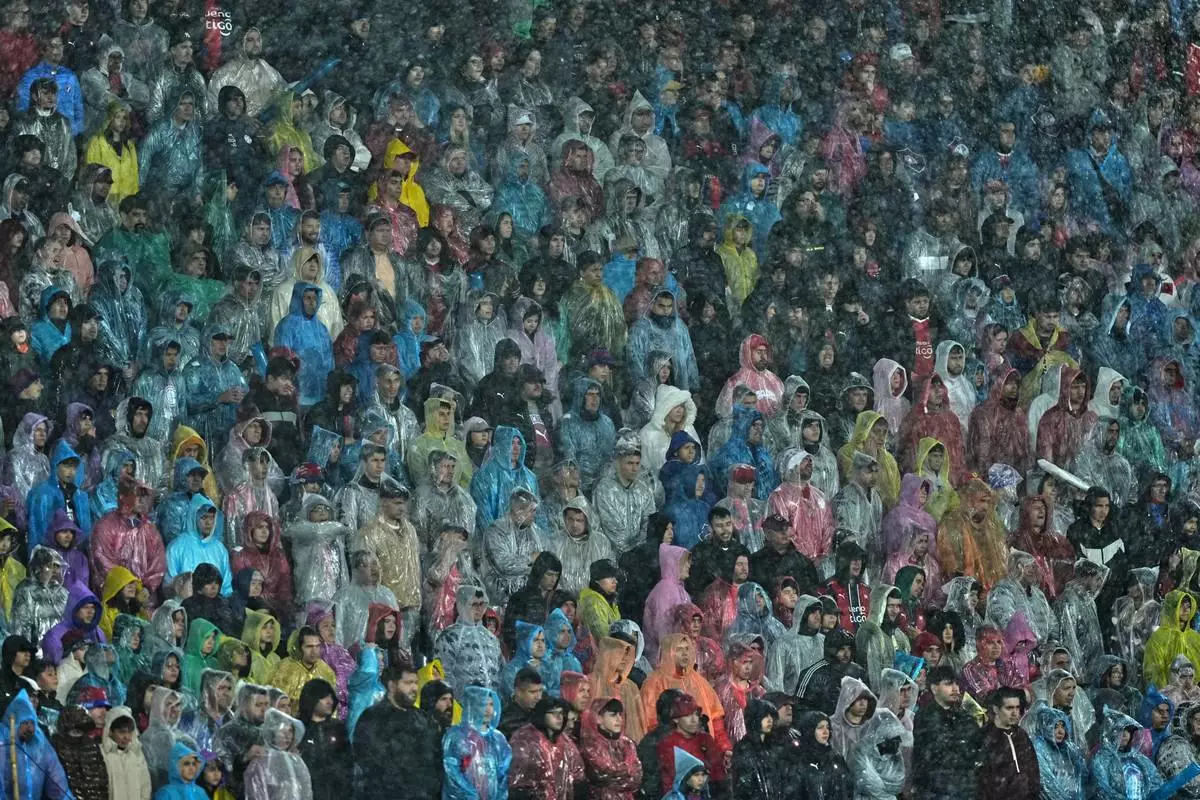 Fans under the rain watch a Copa Libertadores round of sixteen second leg soccer match between Paraguay's Cerro Porteno and Brazil's Palmeiras in Asuncion, Paraguay, Wednesday, Aug. 19, 2026. (AP Photo/Jorge Saenz)