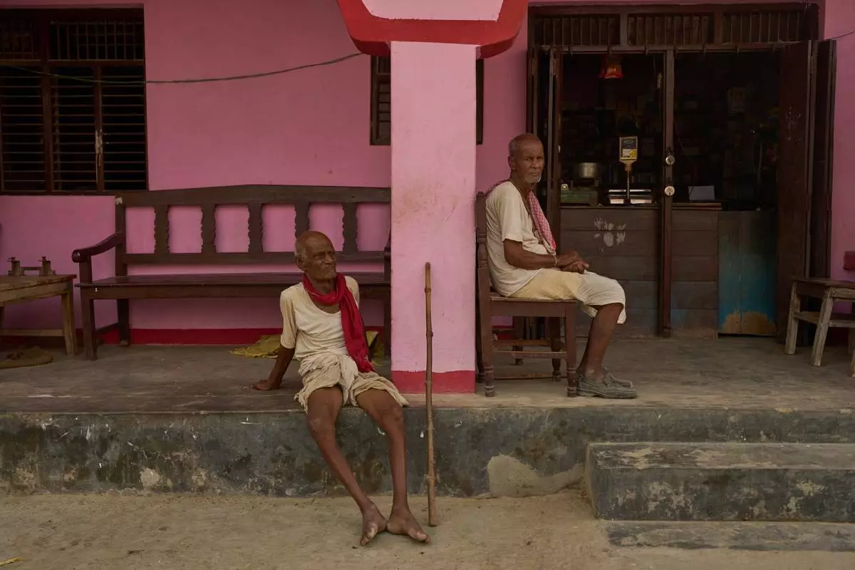 Men sit outside a store in Gaur, Nepal, on May 19, 2026. (AP Photo/Bram Janssen)