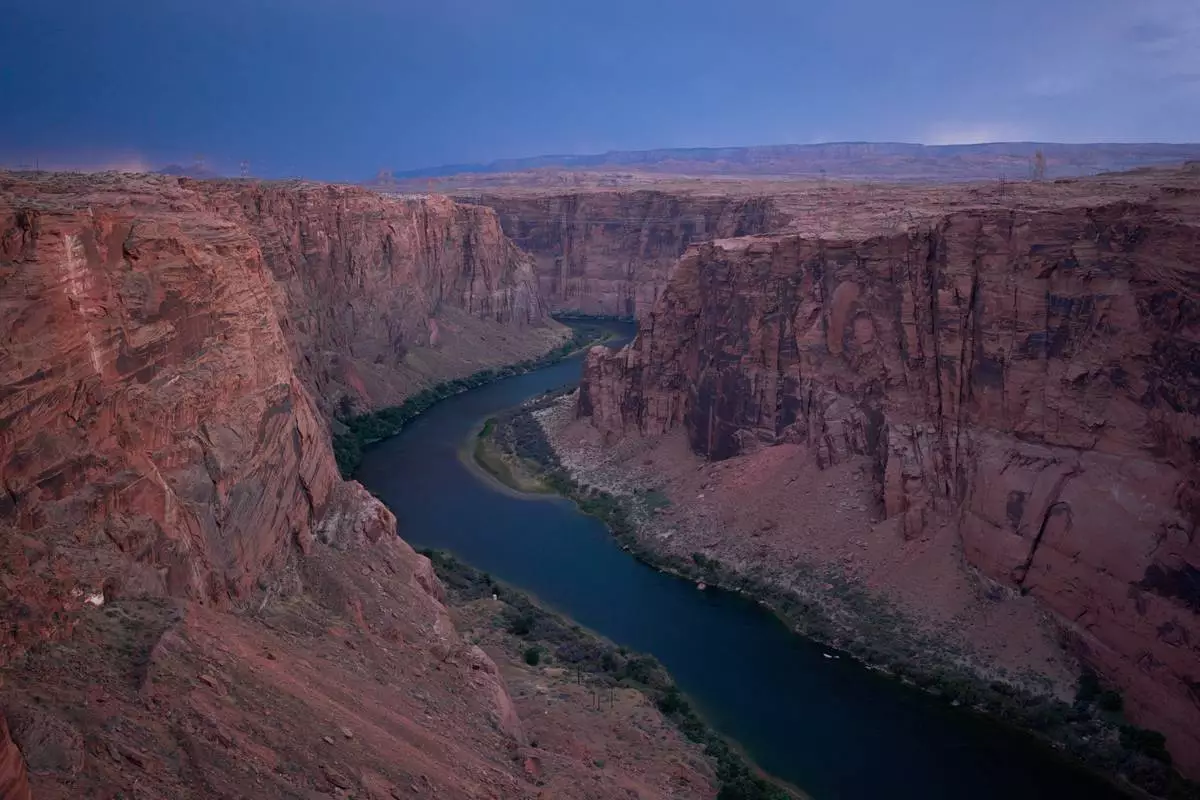 FILE - The Colorado River flows near the Glen Canyon Dam, July 15, 2026, near Page, Ariz. (AP Photo/John Locher, File)