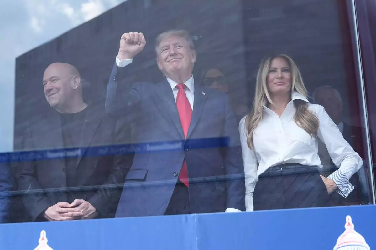 President Donald Trump, first lady Melania Trump and Dana White watch after Kyle Kirkwood (27) won the IndyCar Freedom 250 Grand Prix auto race in Washington, Sunday, Aug. 23, 2026. (AP Photo/Alex Brandon)
