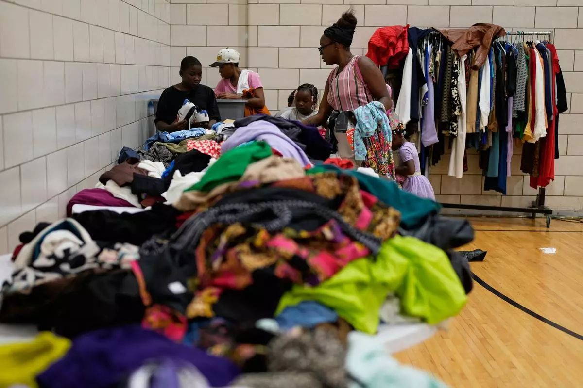 People look through donated clothes at City Life Center in Gary, Ind., Thursday, Aug. 20, 2026, more than a week after a deadly storm passed through the area. (AP Photo/Nam Y. Huh)