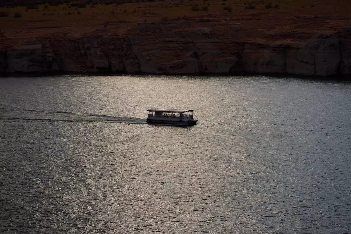 People boat on Lake Powell at the Glen Canyon National Recreation Area, Tuesday, July 14, 2026, near Page, Nev. (AP Photo/John Locher)