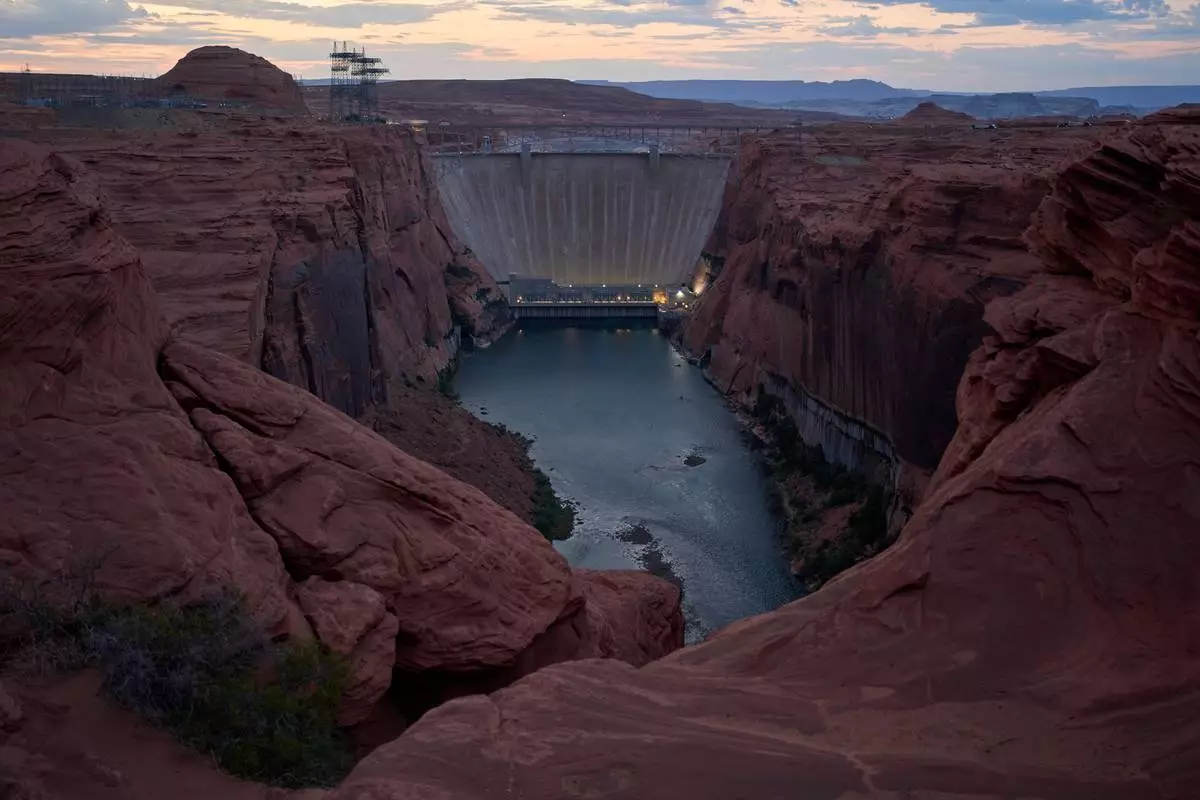 The Colorado River flows beneath the Glen Canyon Dam at the Glen Canyon National Recreation Area, Tuesday, July 14, 2026, near Page, Nev. (AP Photo/John Locher)
