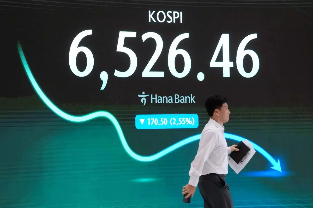 A currency trader passes by a screen showing the Korea Composite Stock Price Index (KOSPI) at the foreign exchange dealing room of the Hana Bank headquarters in Seoul, South Korea, Tuesday, Aug. 25, 2026. (AP Photo/Ahn Young-joon)
