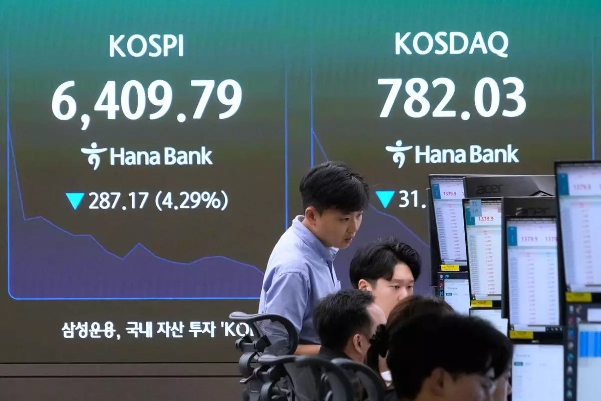Currency traders watch monitors near a screen showing the Korea Composite Stock Price Index (KOSPI) and the foreign exchange rate between U.S. dollar and South Korean won at the foreign exchange dealing room of the Hana Bank headquarters in Seoul, South Korea, Tuesday, Aug. 25, 2026. (AP Photo/Ahn Young-joon)