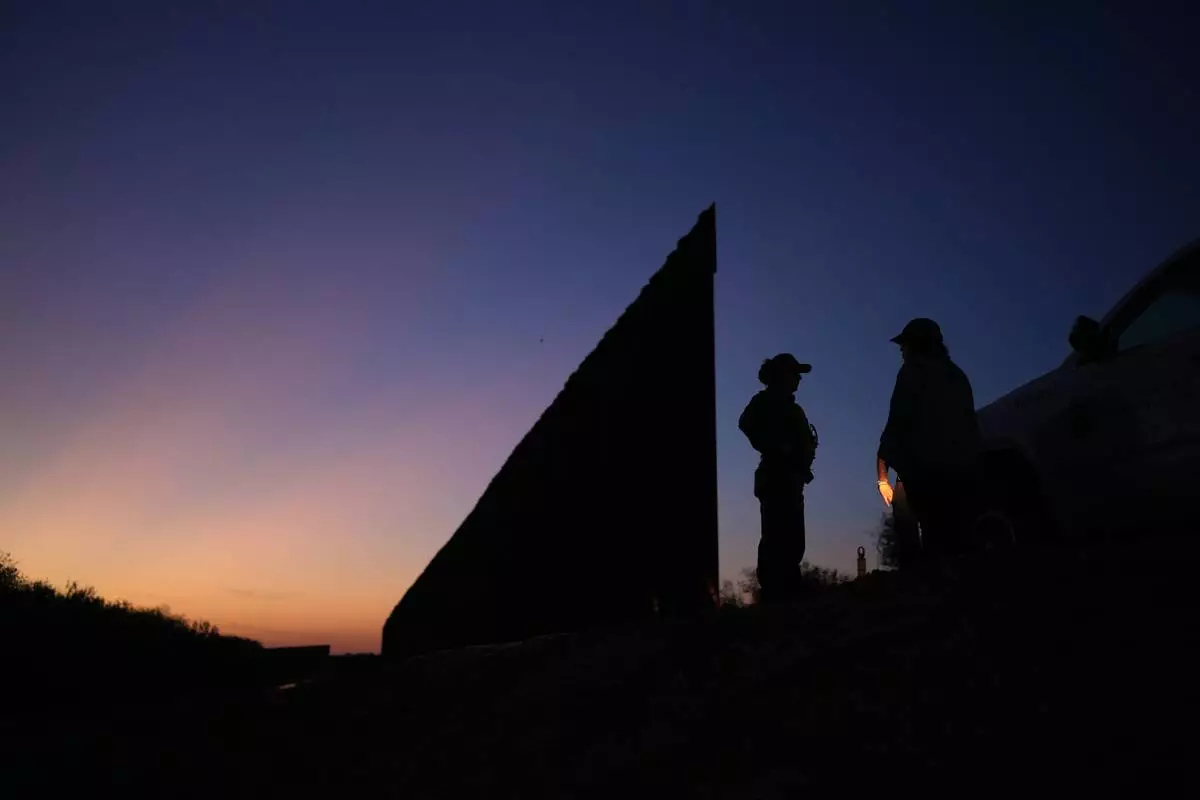 A U.S. Border Patrol agent stands near a new section of border wall at the Santa Ana Wildlife Refuge in Alamo, Texas, Tuesday, Aug. 25, 2026. (AP Photo/Eric Gay)