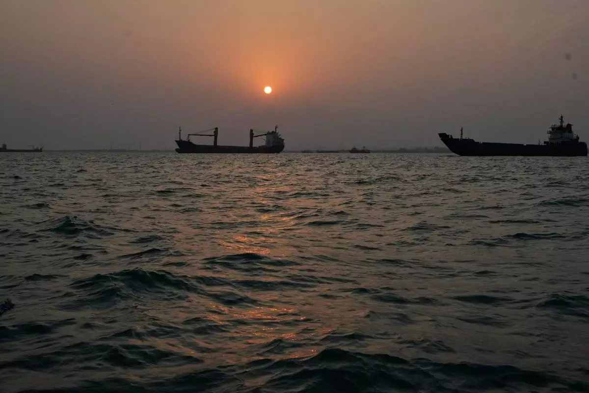 The sun sets over commercial vessels anchored in the Strait of Hormuz off Bandar Abbas, Iran, with the city's skyline in the background, Sunday, Sept. 6, 2026. (AP Photo/Vahid Salemi)