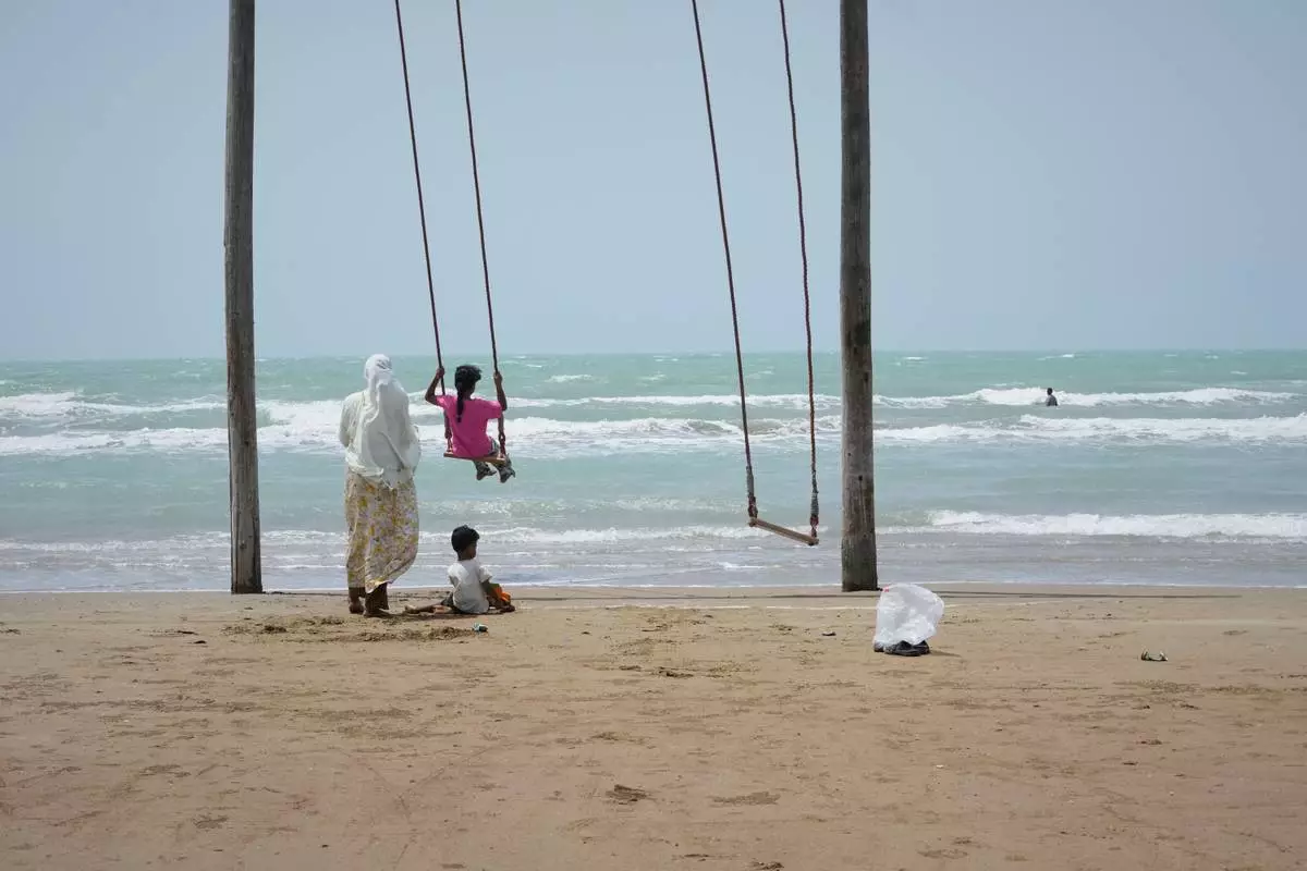 A woman pushes a girl on a swing on a beach along the Strait of Hormuz in Kuhestak, Iran, Friday, Sept. 4, 2026. (AP Photo/Vahid Salemi)