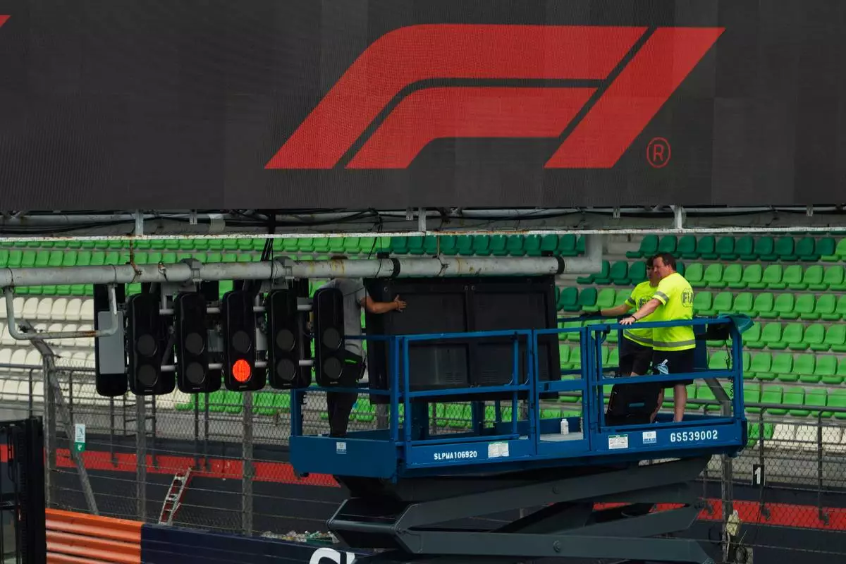 Workers set up trackside signage during preparations for the Bahrain Grand Prix in Malaysia at the Sepang International Circuit in Sepang, Malaysia, Wednesday, Sept. 30, 2026. (AP Photo/Vincent Thian)