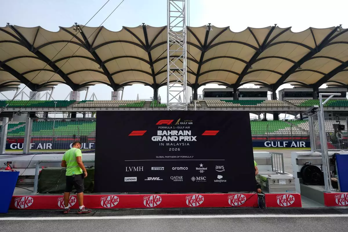 A worker sets up trackside signage during preparations for the Bahrain Grand Prix in Malaysia at the Sepang International Circuit in Sepang, Malaysia, Wednesday, Sept. 30, 2026. (AP Photo/Vincent Thian)