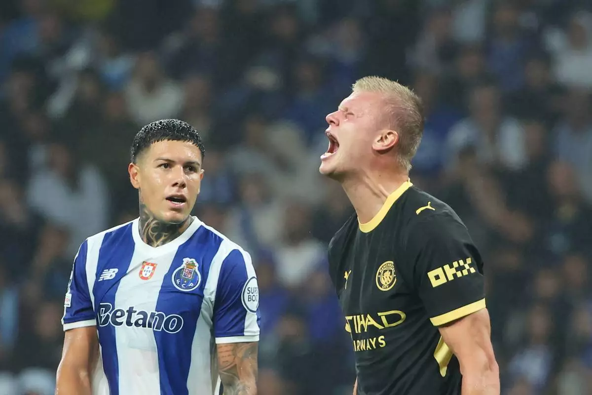 Manchester City's Erling Haaland reacts after a missed chance to score, next to Porto's Nehuen Perez, left, during a Champions League opening phase soccer match between FC Porto and Manchester City in Porto, Portugal, Tuesday, Sept. 8, 2026. (AP Photo/Luis Vieira)