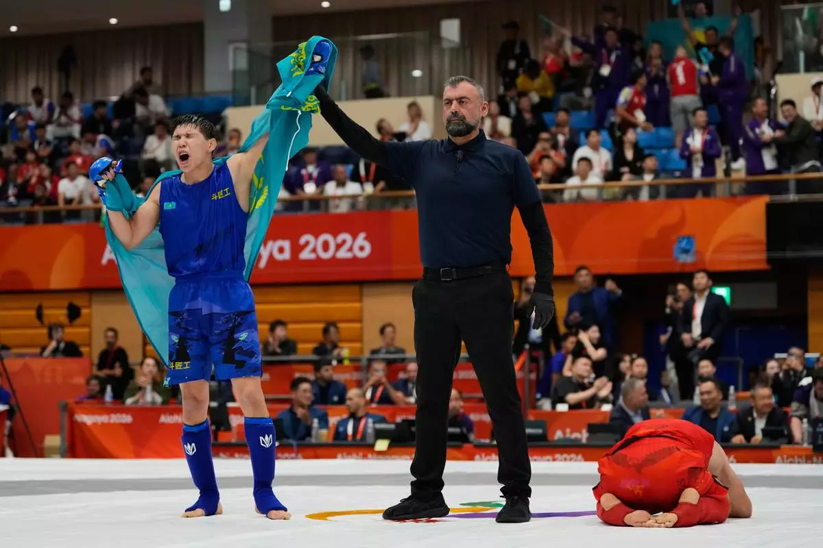 Kadyrbek Shinbayev of Kazakhstan, left, celebrates after winning against Behruz Khurshedzoda of Tajikistan during their men's modern 71kg mixed martial arts final at the Asian Games in Nagoya, Japan, Tuesday, Sept. 22, 2026. (AP Photo/Dita Alangkara)