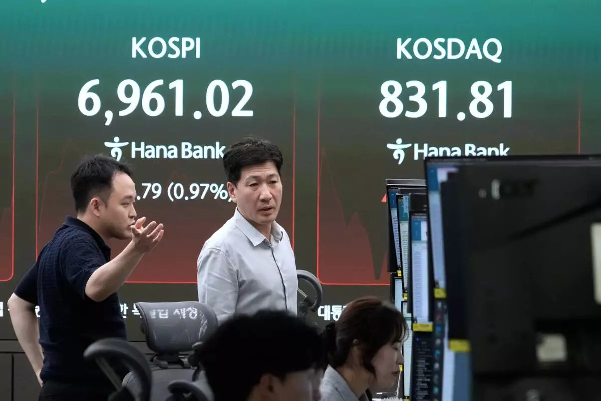 Currency traders work near a screen showing the Korea Composite Stock Price Index (KOSPI) in the foreign exchange dealing room at the Hana Bank headquarters in Seoul, South Korea, Monday, Sept. 21, 2026. (AP Photo/Ahn Young-joon)