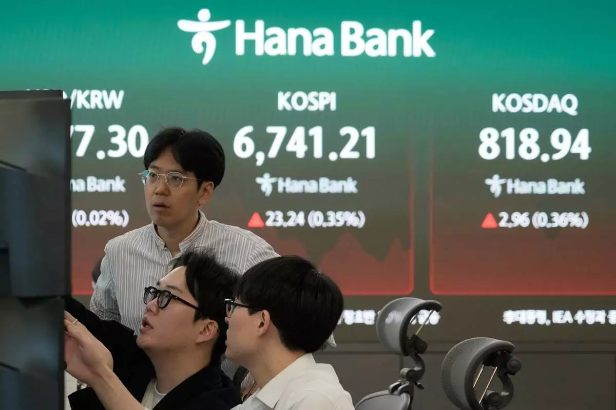 Currency traders watch monitors near a screen showing the Korea Composite Stock Price Index (KOSPI) at the foreign exchange dealing room of the Hana Bank headquarters in Seoul, South Korea, Thursday, Sept. 17, 2026. (AP Photo/Ahn Young-joon)